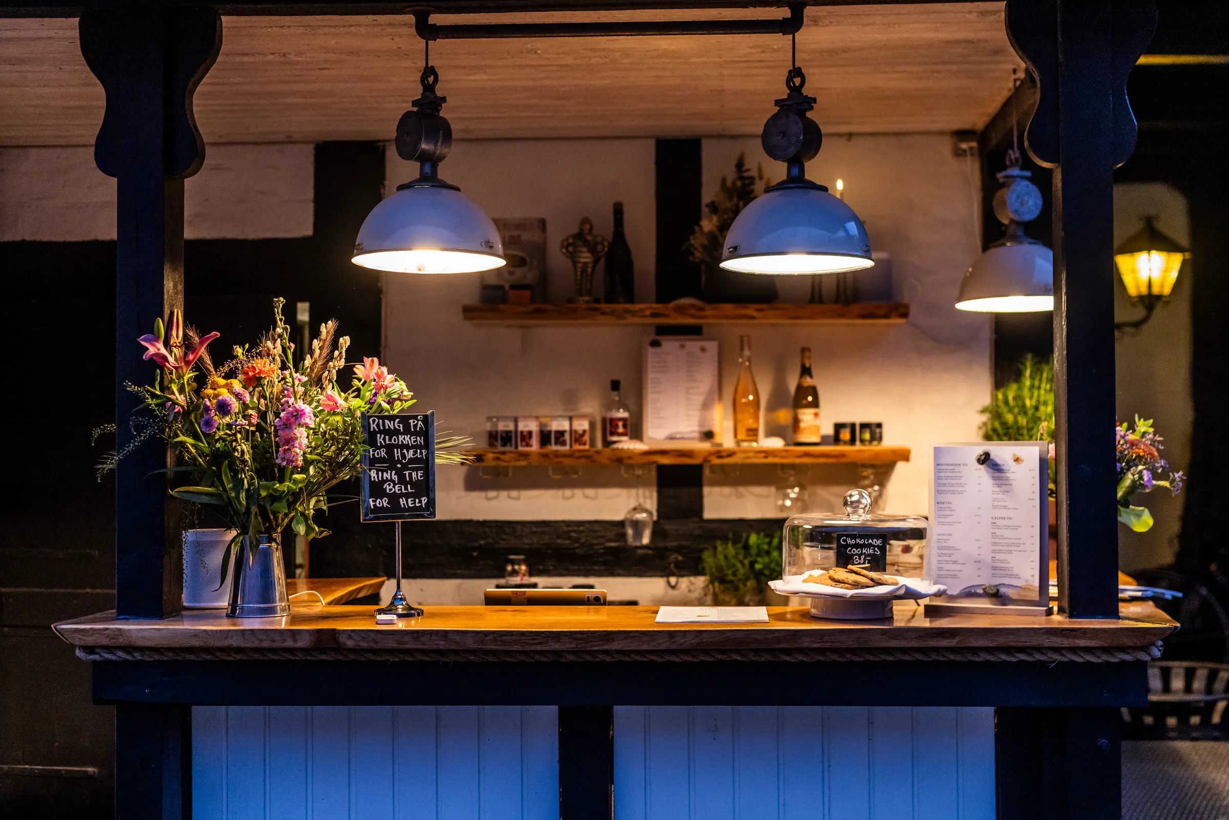 Byskriverbaren ved Allinge Badehotel om aftenen, med blomster og vintavle
